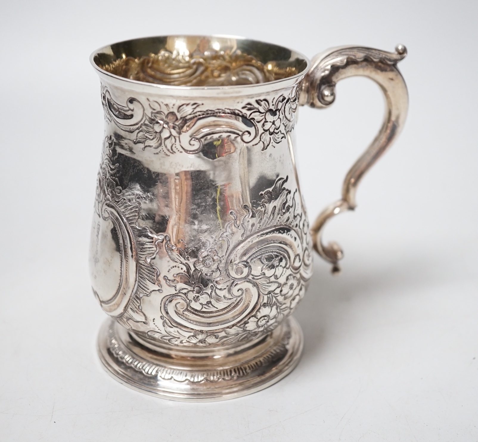 A George III silver mug, with late embossed decoration, John Scofield, 1772, 11.7cm, 9.9oz.